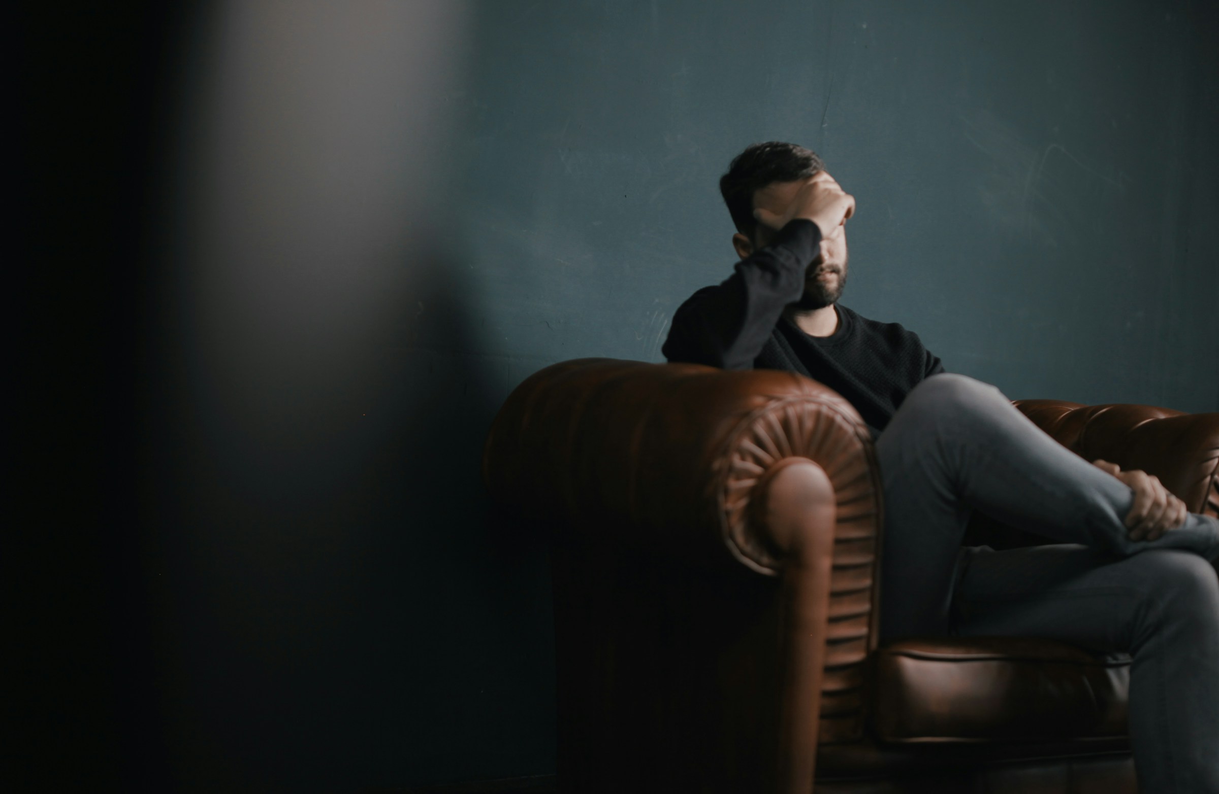 Man stressed sitting down on couch